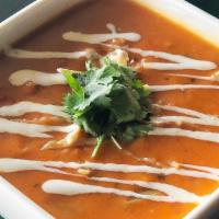 Chicken Tortilla Soup · A spicy, rich soup with shredded chicken, roasted green chiles, crushed tomatoes and corn ma...