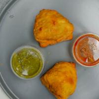 Samosa · Two fried pastries filled with flavored potatoes and peas. Served with chili & tamarind sauce.