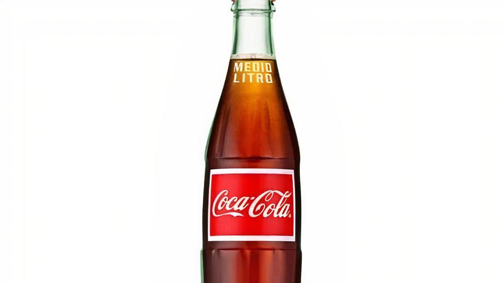 Mexican Coca-Cola · Pair your next meal with a cold Coca-Cola! Subtle notes of vanilla sweetened with real cane sugar. Bottled and served in an old-fashioned glass bottle straight from México. 500ml.
