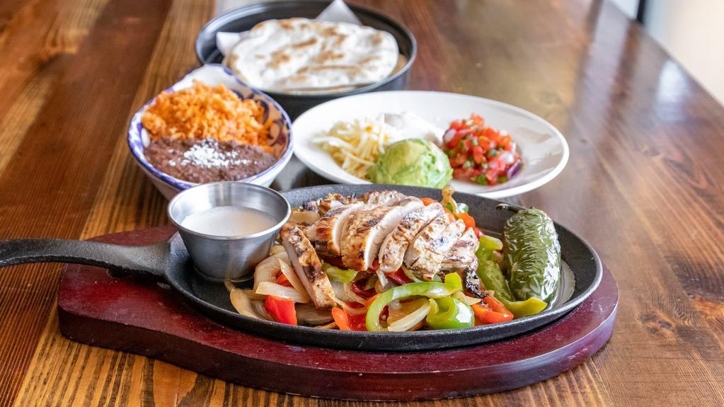 Fajitas · served sizzling with onions & peppers, frothy garlic butter


guacamole, pico de gallo, cheese & sour cream choice of Spanish or cilantro brown rice & charro or refried black beans