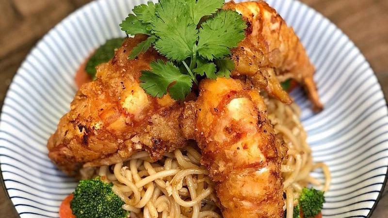 Sunflower Prawns / Tom Rang Muoi · Jumbo Tiger prawns deep fried in our house blend batter and served over buttery egg garlic noodles. Garnished with steamed broccoli, fresh tomato slices, and cilantro.