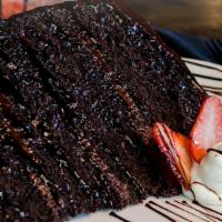 Chocolate Cake · Decadent chocolate cake topped with caramel sauce, chocolate sauce, whipped cream & seasonal...