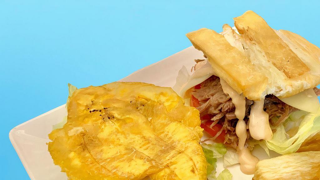 Jibarito · Slow-cooked pork butt, Swiss cheese, lettuce, tomatoes, avocado sauce and mayo-ketchup placed between a fried cassava and plantain bun. Served w/ cassava fries and chimichurri sauce