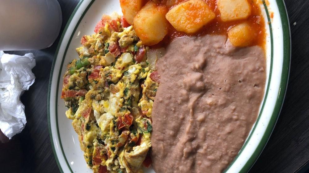Huevos A La Mexicana · Scrambled eggs with onions, tomatoes and jalapeno. Served with beans and potatoes.