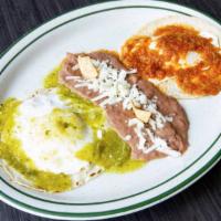 Huevos Divorciados · Two eggs, one topped with ranchero sauce and one topped with tomatillo sauce, laid over a co...