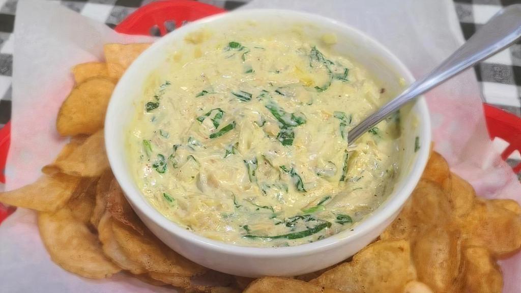 Spinach Artichoke Dip · Artichoke hearts, fresh garlic, wilted spinach, and a blend of fine Italian cheeses melted together and served with house-made kettle chips.