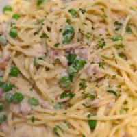 Spaghetti Carbonara · Crispy pancetta, green peas, red chili flakes, and spaghetti tossed in a creamy egg sauce wi...