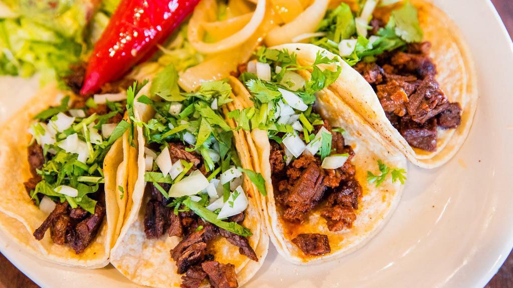 Street Tacos · Four small corn tortilla tacos with your choice of carnitas, brisket, ground beef or ranchero chicken, served with guacamole, sour cream, and charro beans.