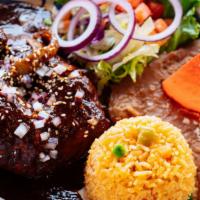Signature Mole Poblano · Tender chicken slowly cooked in the traditional mole sauce. Served with rice, refried beans,...
