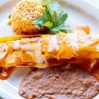Pork Tamale Dinner · Three tamales topped with gravy and cheese.