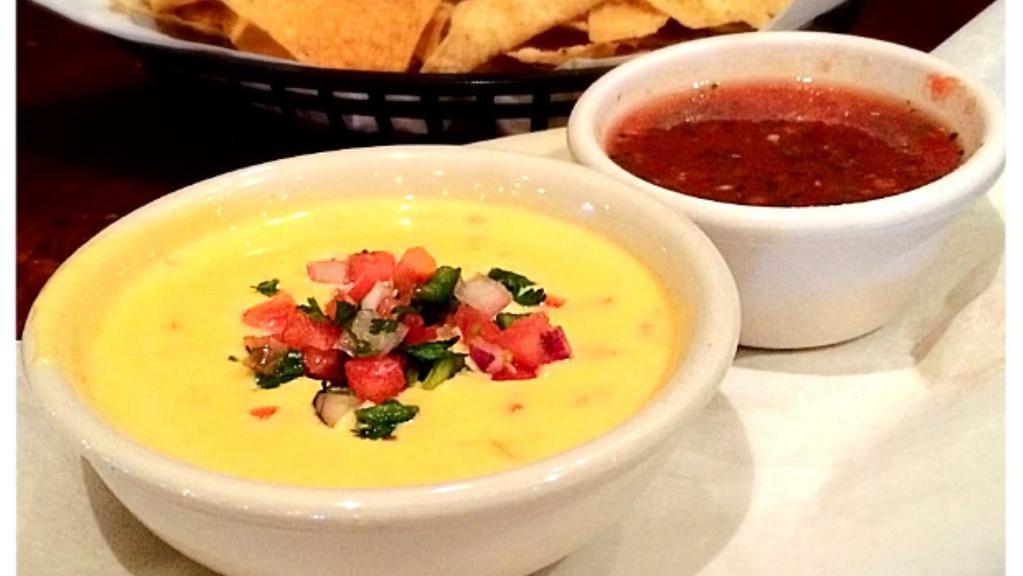 Tostada Chips & Queso · Bowl of house-made queso topped with pico de gallo and served with a side of salsa.