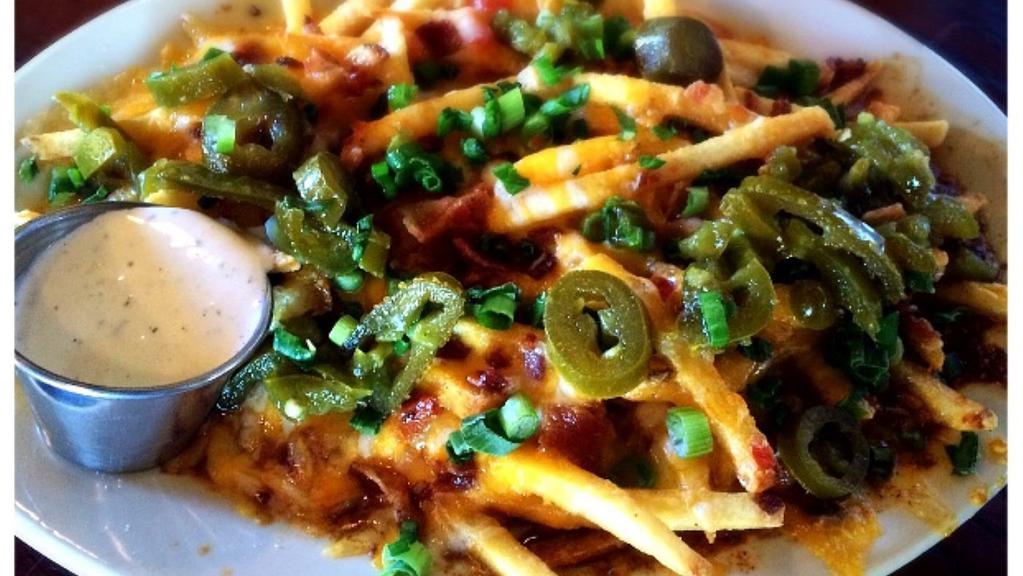 Cheese Fries Surprise · Loaded with cheddar, bacon, chives, and jalapenos served with ranch and ketchup.  The surprise is a layer of queso and ground beef underneath.