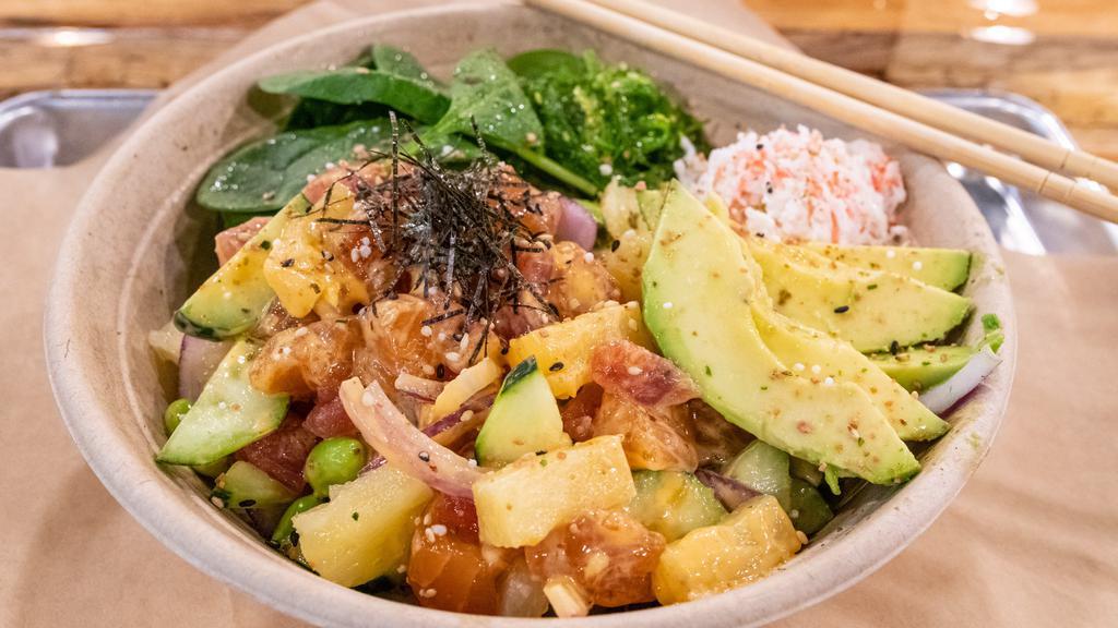 Poke Bowl · A Hawaiian fish salad. Fresh sushi grade salmon and tuna mixed with pineapples, roasted corn, cucumber, edamame seeds, and firecracker sauce on top of sushi white rice. Also comes with a splash of spinach, sweet onions, creamy crab salad, seaweed salad, a dash of furikake seasoning, shredded nori, and toasted sesame seeds. We finish off the bowl with a glaze of unagi sauce.