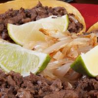 Tacos De Bistec · Five small corn tortillas chopped beef steak grilled onions charros beans.