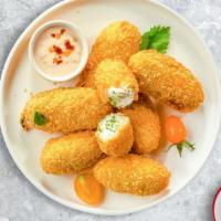 Spicy Poppers · Fresh jalapenos coated in cream cheese and fried until golden brown. Seven pieces.