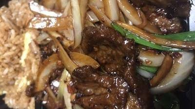 Mongolian Beef · Green onions and white onions with brown sauce.