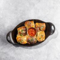 Warm Garlic Knots · By Zoli's NY Pizza. Smothered in schmutz and pecorino. Comes with marinara. Contains gluten....