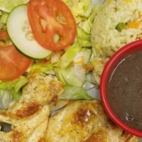 Pechuga De Pollo Ala Plancha · Grilled chicken breast with rice and salad.