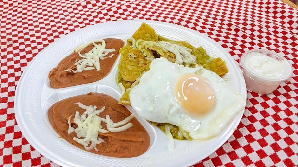 Chilaquiles Verde · Tortilla banada en salsa  verde, acompanada con 1 huevo frito o revuelto, frijoles, y creme. 
Fried Tortilla slices cooked in green salsa topped with cheese. Served with 1 egg fried or scrambled, beans and sour cream.