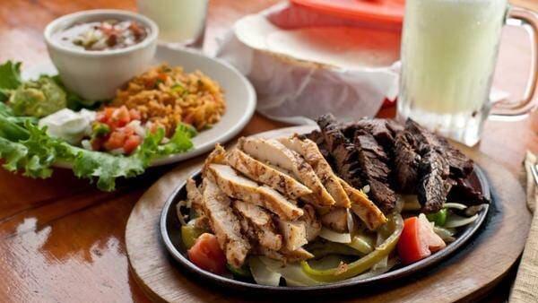 Fajitas · Served with fresh flour tortillas, grilled onions, peppers, tomatoes, rice, refried beans, pico de gallo, sour cream and choice of either guacamole or cheddar cheese.
