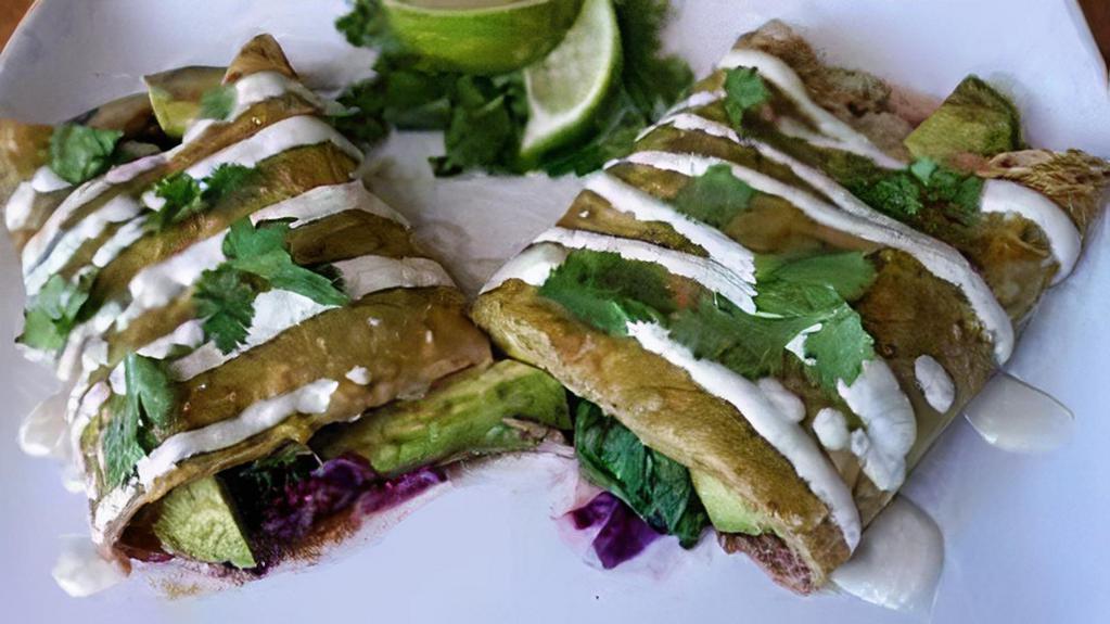Avocado Enchiladas · Fresh avocado, mushrooms, poblano peppers and jack cheese in corn tortillas, topped with Verde sauce, cilantro and sour cream drizzle. Spinach. With rice and refried beans.