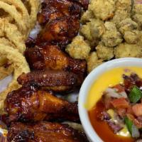 Red River Sampler · Smoked Wings, Fried Mushrooms, Onion Rings & Texas Queso with tortilla chips.