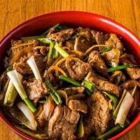 Mongolian Beef · Stir-fry beef with green onion and yellow onion served on top of rice