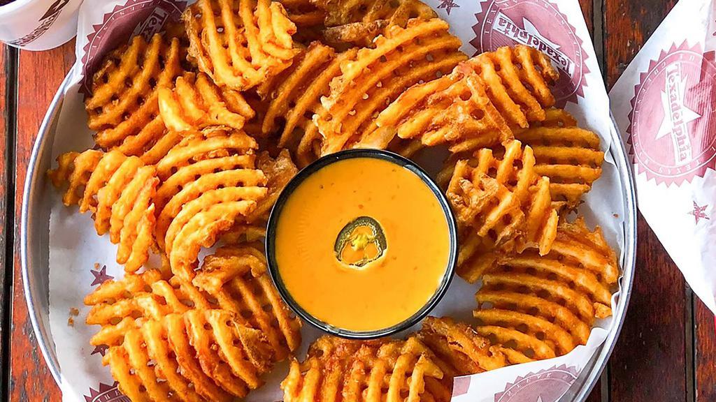 Queso Waffle Fries · Our signature waffle fries, served with a bowl of Texadelphia's famous queso.