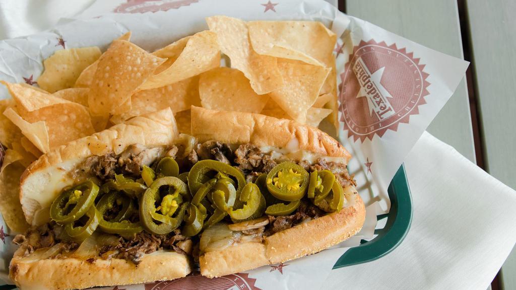 The Texican · Beef or Chicken, Grilled Onions, Mozzarella, Jalapeños, 2oz. Queso on Side.