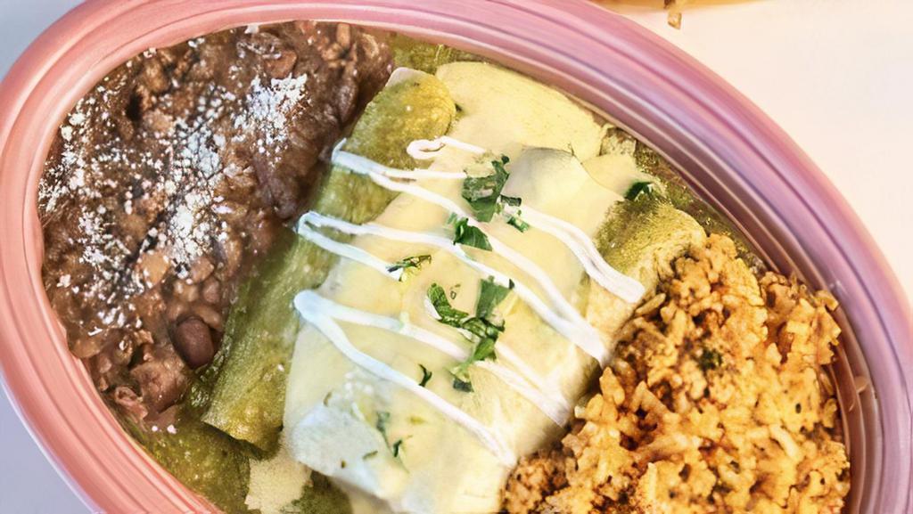 Enchiladas Verdes · Shredded Chicken Roasted Tomatillo Sauce, Refried Beans and Mexican Rice.