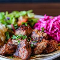 Lamb Kebab · Skewered, charbroiled lamb kebabs served with onion salad, grilled tomatoes and peppers, pic...