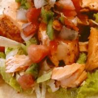 Salmon Tacos · Pan-seared salmon nestled on top of a flour tortilla layered with a guacamole spread, then t...
