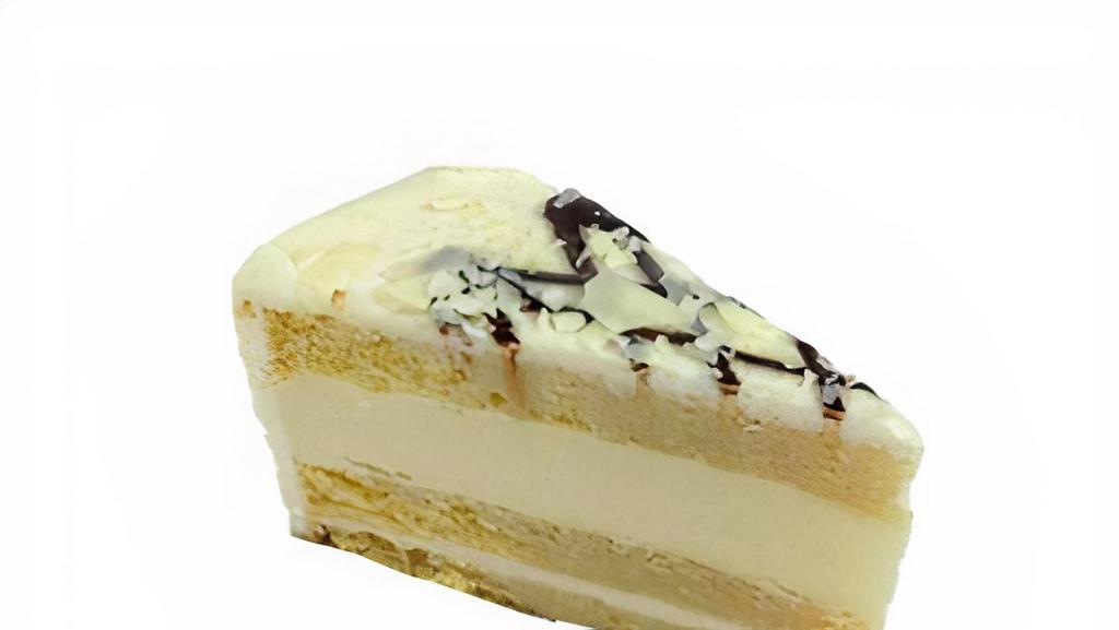 Tres Leches Cheesecake · Made with Vanilla sponge cake infused with three condensed milks.  It is topped with white chocolate shavings.