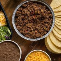 Taco Family Meal · A dozen tacos with your choice of beans, Spanish rice, red & green salsa, queso and chips.