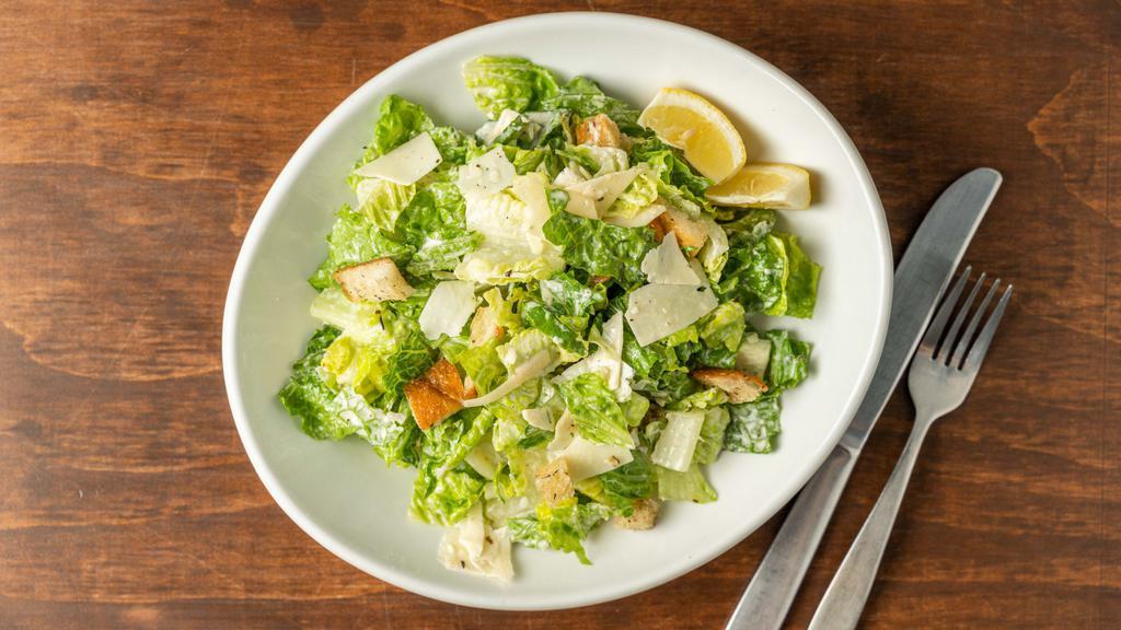 Caesar  · Romaine lettuce, croutons, shaved parmesan and Caesar dressing with side of lemons.