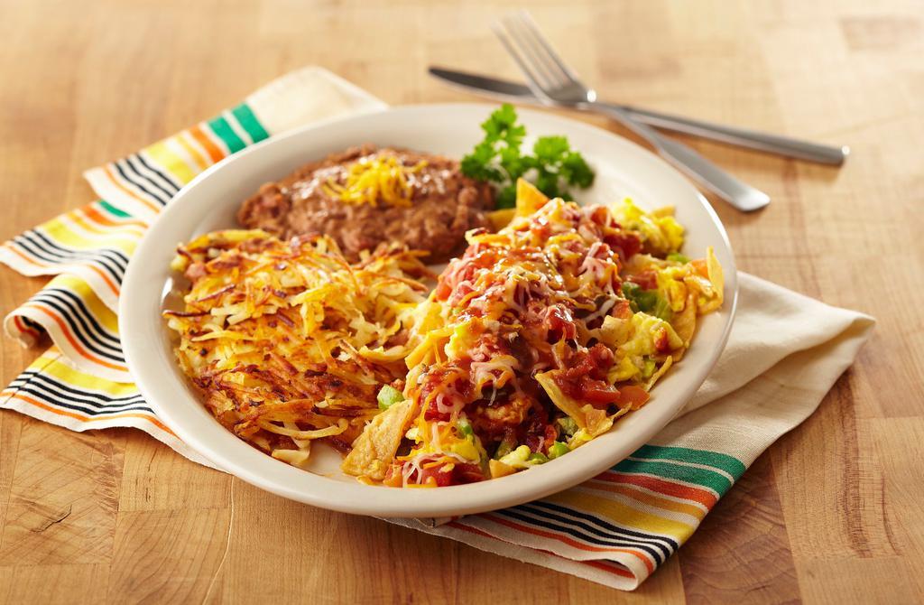 Migas · Three eggs scrambled with diced bell peppers, tomatoes, onions, corn tortilla strips and frontier ranchero sauce. Then topped with cheddar and Monterey jack cheese, served with refried beans, golden hash browns and flour tortillas.