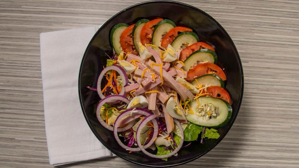 Chef · Fresh romaine and iceberg lettuce topped with shredded carrots, red cabbage, tomatoes, cucumbers, red onions, shredded cheese, sliced ham and turkey, and boiled egg.