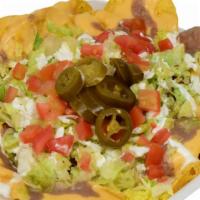 Nachos Supreme · Nacho chips with nacho cheese, beans, lettuce, your choice of protein, tomato, sour cream an...
