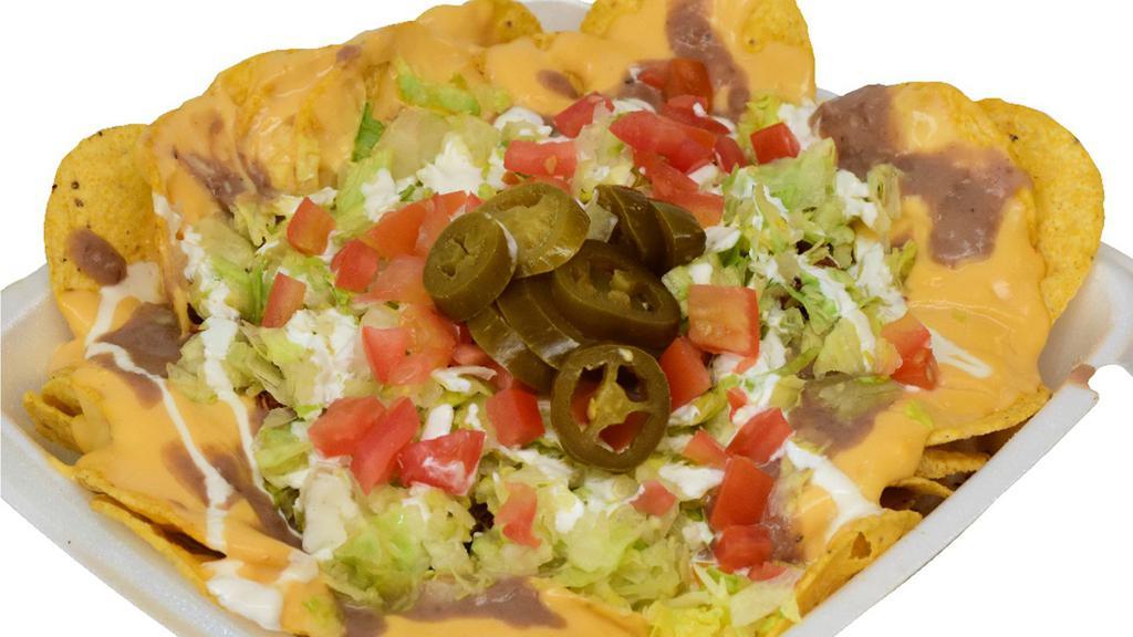 Nachos Supreme · Nacho chips with nacho cheese, beans, lettuce, your choice of protein, tomato, sour cream and jalapeños.