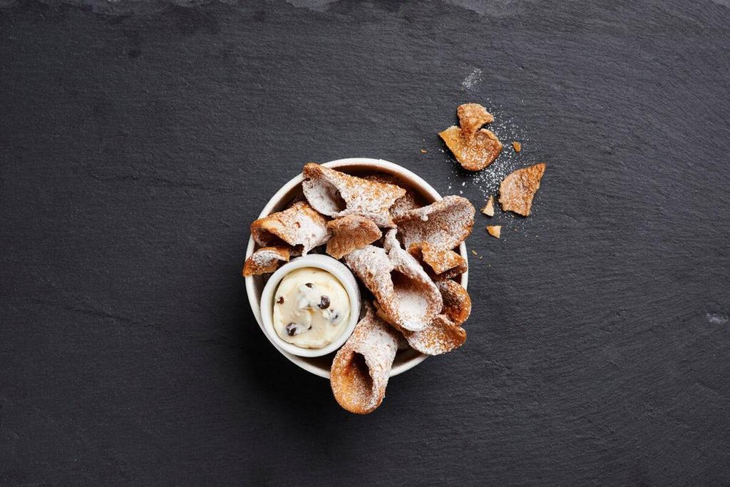 Cannoli Chips · Holy cannoli! The perfect dessert has arrived. Try our new crispy cannoli chips tossed in powdered sugar and served with chocolate chip cannoli cream