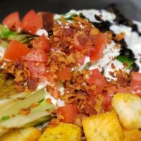 Grilled Romaine Wedge · Lightly grilled and topped with bleu cheese dressing, bacon, tomatoes, and croutons.