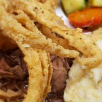 Cajun Pot Roast · Slow roasted pot roast with gravy, topped with fried onions. Served with two sides.