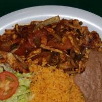Bistec Ranchero / Steak Ranch Style · Trozos de fajita de pollo o res con cebolla, tomate y jalapeños. Con arroz y frijoles refrit...