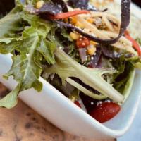 Iron Salad · Seasonal greens, roasted corn and tomatillo relish, cotija cheese, tortilla strips.