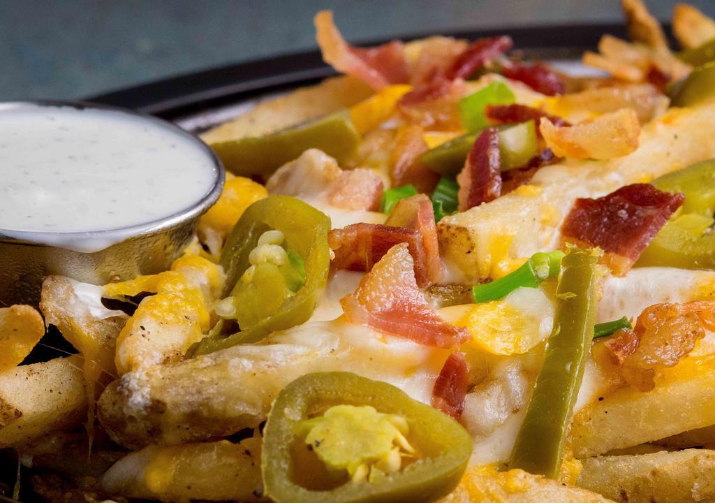 Loaded Cheese Fries · One pound of French fries flavored with homemade seasoning, topped with cheddar, Monterey jack cheese, bacon, chives, and jalapeños and served on a hot skillet with buttermilk ranch upon request.