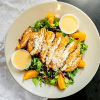 Coconut Chicken Salad · Fresh greens, coconut chicken, oranges and dried cranberries, served with our homemade honey...