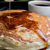 Pancakes · Three large pancakes served with syrup and butter.