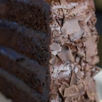 Chocolate Layer Cake · Drizzled chocolate icing cascades over four indulgent layers of moist cake and fudgy frostin...