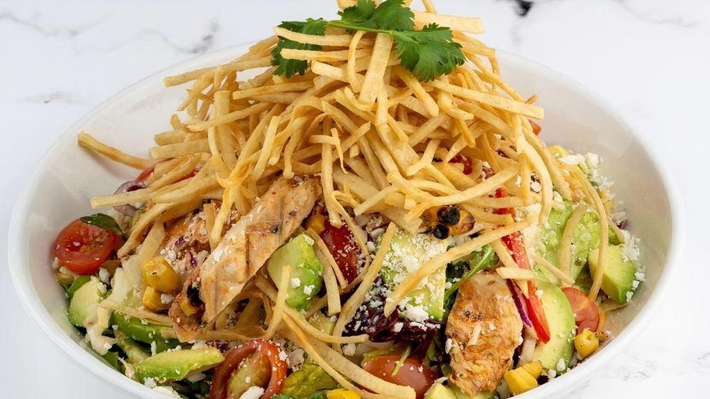 Southwest Smoked Chicken Salad · Mesquite smoked chicken, roasted sweet corn, red peppers, avocado, cherry tomatoes, marinated jicama and cilantro tossed with fresh spring greens, and our Napa slaw. Topped with Cotija cheese and crispy tortilla strips. Served with Cilantro Lime Vinaigrette.