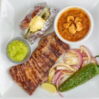 Arrachera · Tender skirt steak served with charro beans, grilled onions, chile toreado and choice of bak...